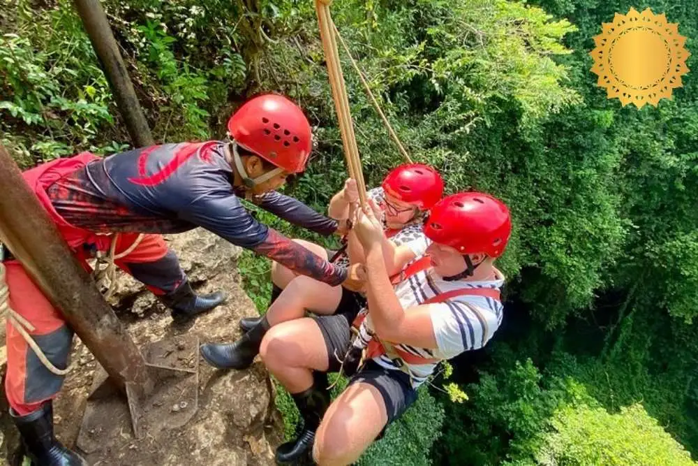 Tourists descending into Jomblang Cave with safety gear and guide